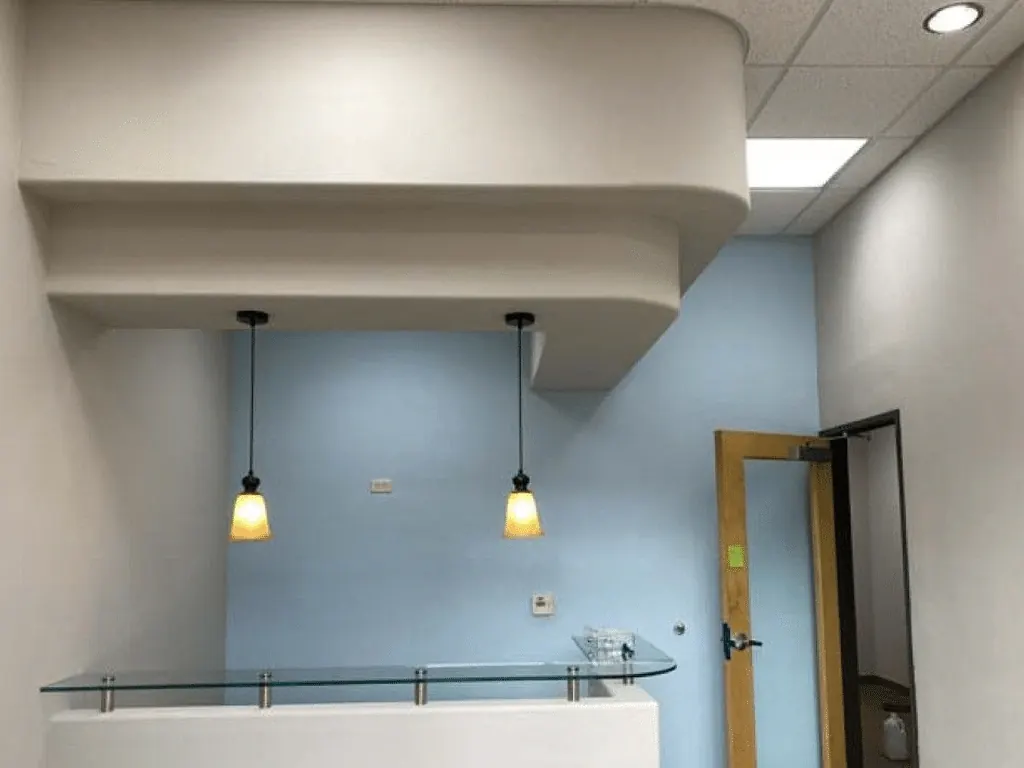 Office reception desk with pendant lights and freshly painted blue walls